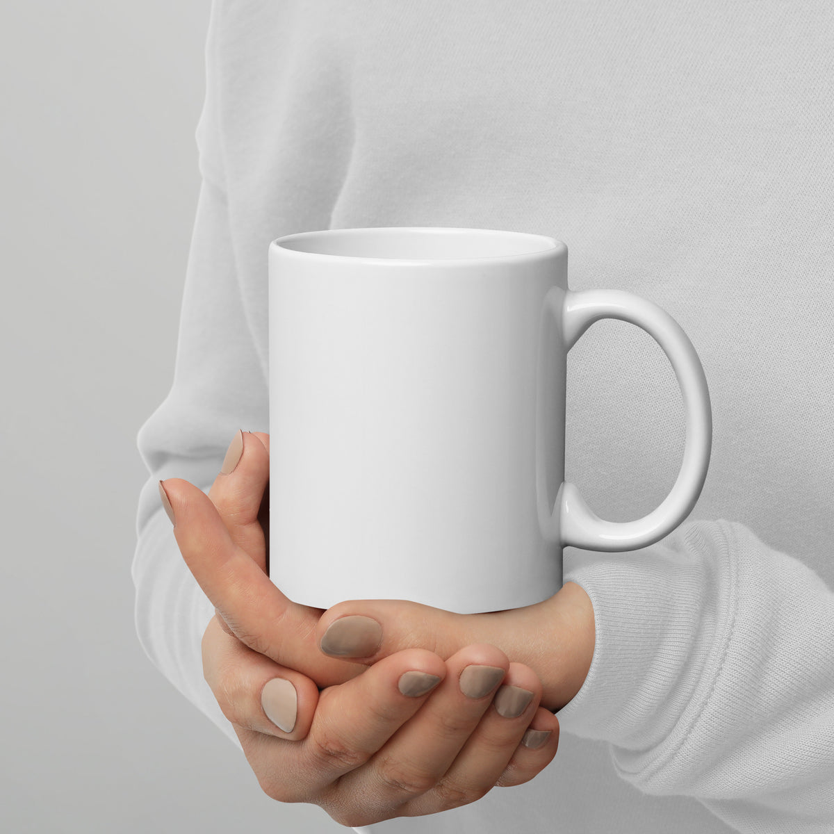 Plain white ceramic mug held in one hand, minimal design